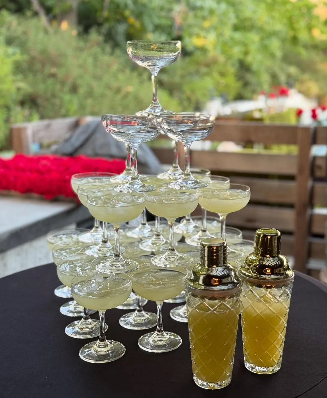 A tower of coupe glasses at an outdoor wedding