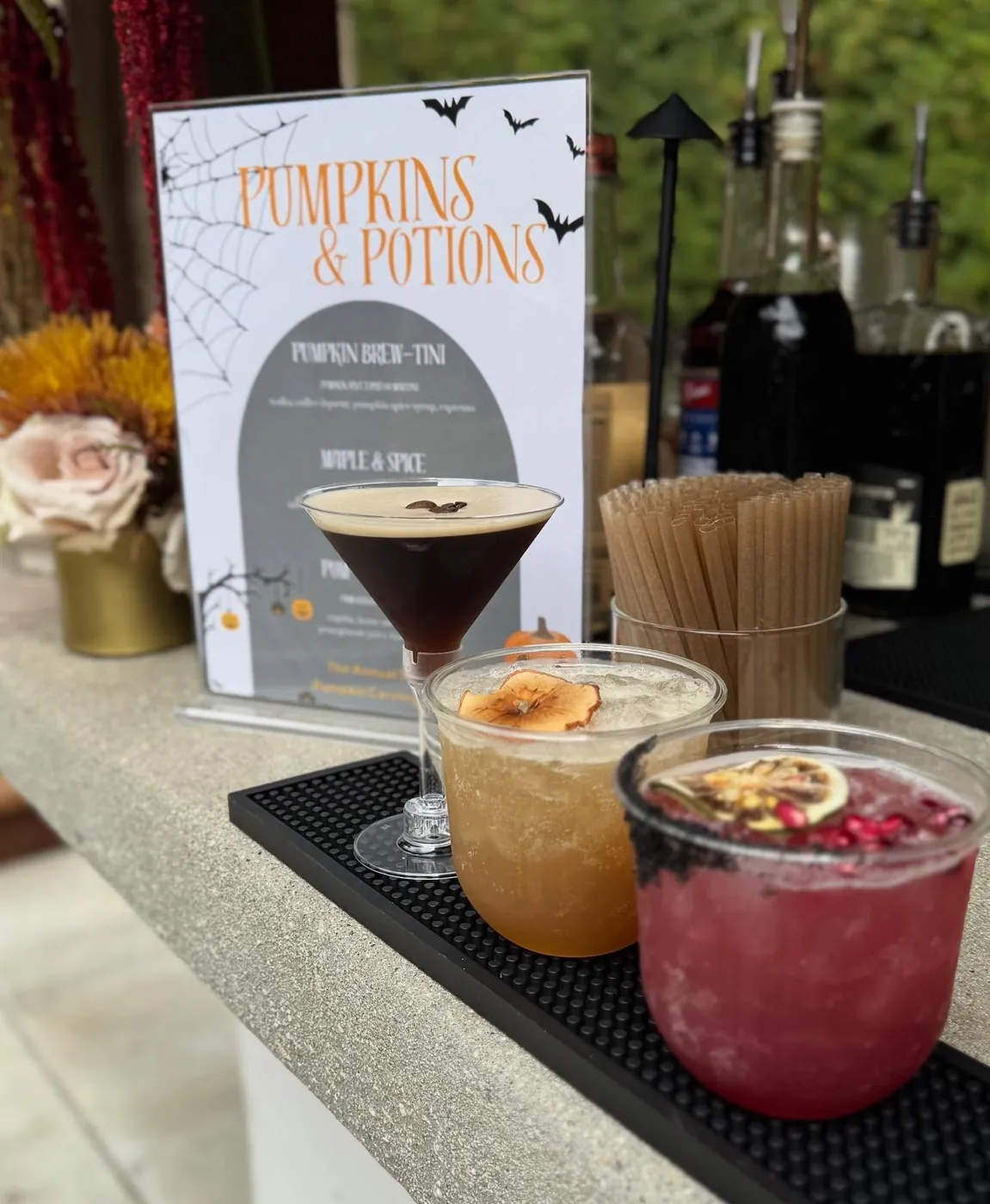 A whiskey smash and espresso martini on a bar beside a printed menu
